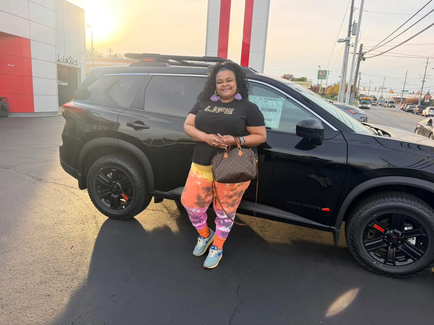 Ciara posing next to her black Nissan Rogue